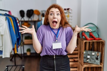 Sticker - Young redhead woman working as manager at retail boutique celebrating crazy and amazed for success with arms raised and open eyes screaming excited. winner concept