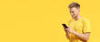 © Pixel-Shot - Portrait of happy young man with mobile phone on yellow background with space for text