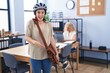 © Krakenimages.com - Young brunette woman working at the office wearing bike helmet smiling happy pointing with hand and finger