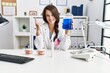 © Krakenimages.com - Young dentist woman holding mouthwash for fresh breath smiling with an idea or question pointing finger with happy face, number one