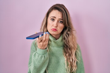 Sticker - Young caucasian woman sending a voice message with smartphone depressed and worry for distress, crying angry and afraid. sad expression.