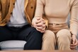 © Krakenimages.com - Mand and woman couple sitting on sofa with hands together at home