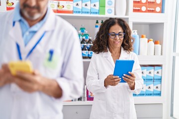 Sticker - Man and woman pharmacists using touchpad and smartphone working at pharmacy