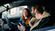 © Krakenimages.com - Man and woman couple using smartphone sitting on car at street