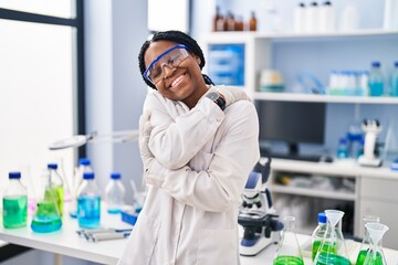 Sticker - African american woman working at scientist laboratory hugging oneself happy and positive, smiling confident. self love and self care