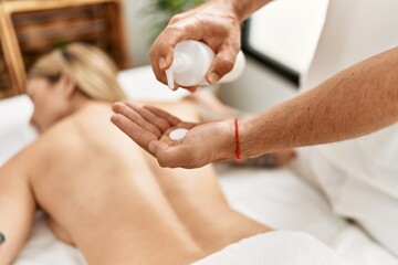 Canvas Print - Young caucasian woman at physiotherapy clinic getting muscle massage by professional therapist. Physiotherapist man doing rehabilitation treatment to client