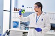 © Krakenimages.com - Young man wearing scientist uniform holding bottle and clipboard at laboratory
