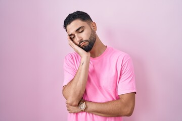 Wall Mural - Hispanic young man standing over pink background thinking looking tired and bored with depression problems with crossed arms.