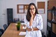 © Krakenimages.com - Young hispanic woman at the office thinking looking tired and bored with depression problems with crossed arms.