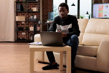 Wall Mural - african american employee working on laptop to plan business presentation and new software developin