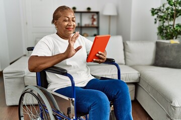 Poster - Senior african american woman having video call sitting on wheelchair at home