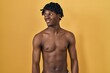 © Krakenimages.com - Young african man with dreadlocks standing shirtless looking away to side with smile on face, natural expression. laughing confident.