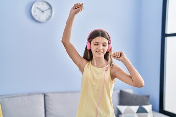 Sticker - Adorable girl listening to music and dancing at home