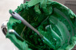 bowl of deep green icing with a spatula