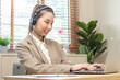 Operator, smile asian young woman wearing headset, headphones and speaking on video call conference with customer, colleagues support phone, work on laptop computer.Technology of help, consult service