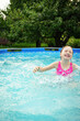 © Анна Молько - A child in the water. A girl splashes in an inflatable pool in the garden on a sunny summer day. High quality photo
