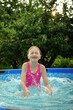 © Анна Молько - A child in the water. A girl splashes in an inflatable pool in the garden on a sunny summer day. High quality photo