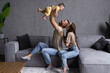 © F8  \ Suport Ukraine - Happy young parents play have fun with excited little son in living room.