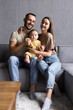 © F8  \ Suport Ukraine - Happy young aucasian family with small son relax on sofa in living room