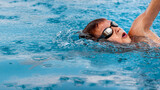 Fototapeta  - Boy child swimmer swim in swimming pool. Water sports, training, competition, activities, learning to swim school classes for children