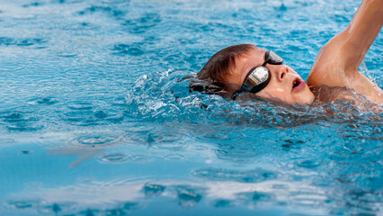 Boy child swimmer swim in swimming pool. Water sports, training, competition, activities, learning to swim school classes for children