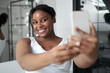 © gpointstudio - Young African-American woman making a selfie in the bathroom