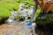 © Antonioguillem - Hiker hand filling canteen of raw water in a creek
