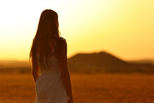 Woman Silhouette Standing In A Wheat Field At Sunset
