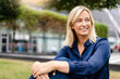 © Westend61 - Mature smiling businesswoman sitting in park