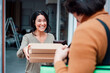 © Westend61 - Happy woman receiving parcel from delivery man