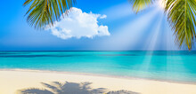 Panoramic Landscape View Of White Beach Sand Sea Water And Blue Sky Clear Background. Tropical Paradise Banner, Closeup Palm Leaves. Summer Travel Background, Wallpaper Panorama. Sunny Beach Scene