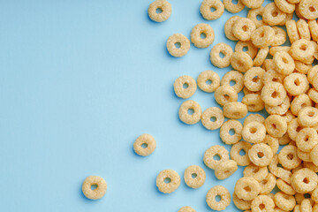 Wall Mural - Cornflakes rings for breakfast on a blue background.