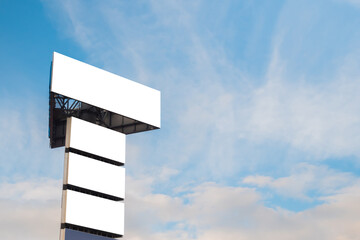 Wall Mural - mock up image: four blank white billboards or large displays on tower against blue sky with clouds. 
