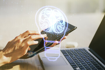 Wall Mural - creative light bulb illustration with human brain and with finger presses on a digital tablet on bac