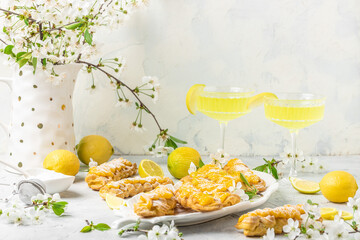 Limoncello. Traditional italian homemade alcoholic drink in glass with pieces of lemon, sweet Italian lemon liqueur on a light background. Long banner format. top view