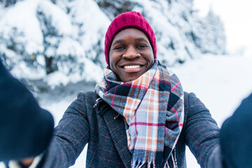 african man taking picture by smartphone selfie outdoors in winter forest