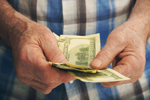 Close-up Of Senior Man's Hands Holding Money 100 Dollar Bills.