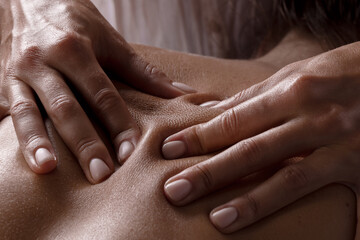 masseur girl makes a massage close-up on a dark background. close-up massage