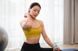 © chachamp - Asia sport woman break time with holding pure water in plastic bottle after exercise training in living room