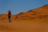 Fototapeta  - A Beautiful Model Poses In The Sand Dunes In The Great Sahara Desert In Morocco, Africa
