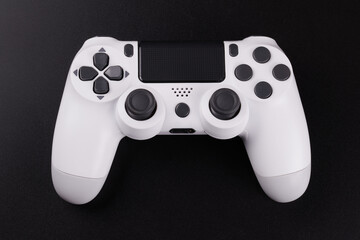 White video game controller, joystick for game console isolated on black background. Gamer control device close-up