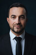 © Serhii Savchenko - Close-up portrait of a modern man in a trendy suit, a man in a black suit on a dark background