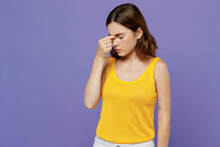 Young Sad Ill Sick Exhausted Woman 20s She Wearing Yellow Tank Shirt Keep Eyes Closed Rub Put Hand On Nose Isolated On Plain Pastel Light Purple Background Studio Portrait. People Lifestyle Concept.