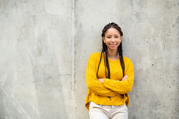 Wall Mural - Portrait of beautiful young black woman standing by exterior wall