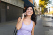 Happy woman talking on mobile phone in city