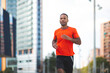 © mimagephotos - Fit man jogging outdoors in city