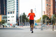 © mimagephotos - Male athlete running outdoors on city street