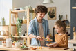 © Mediaphotos - Little boy helping his mother to cook dinner in the kitchen, they preparing vegetable salad together