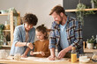 © Mediaphotos - Parents teaching their little son to bake homemade pie from dough at table in kitchen