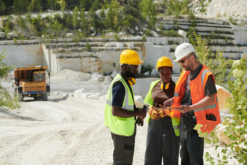 Aufkleber - Confident foreman in safety helmet and workwear making presentation to his colleagues of new industrial project on territory of marble quarry